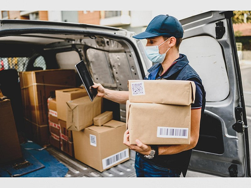 Delivery man brings packages in LCV